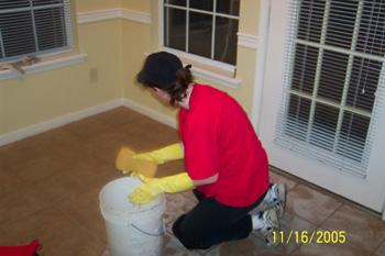 Stacy sponging off excess grout from the tiles